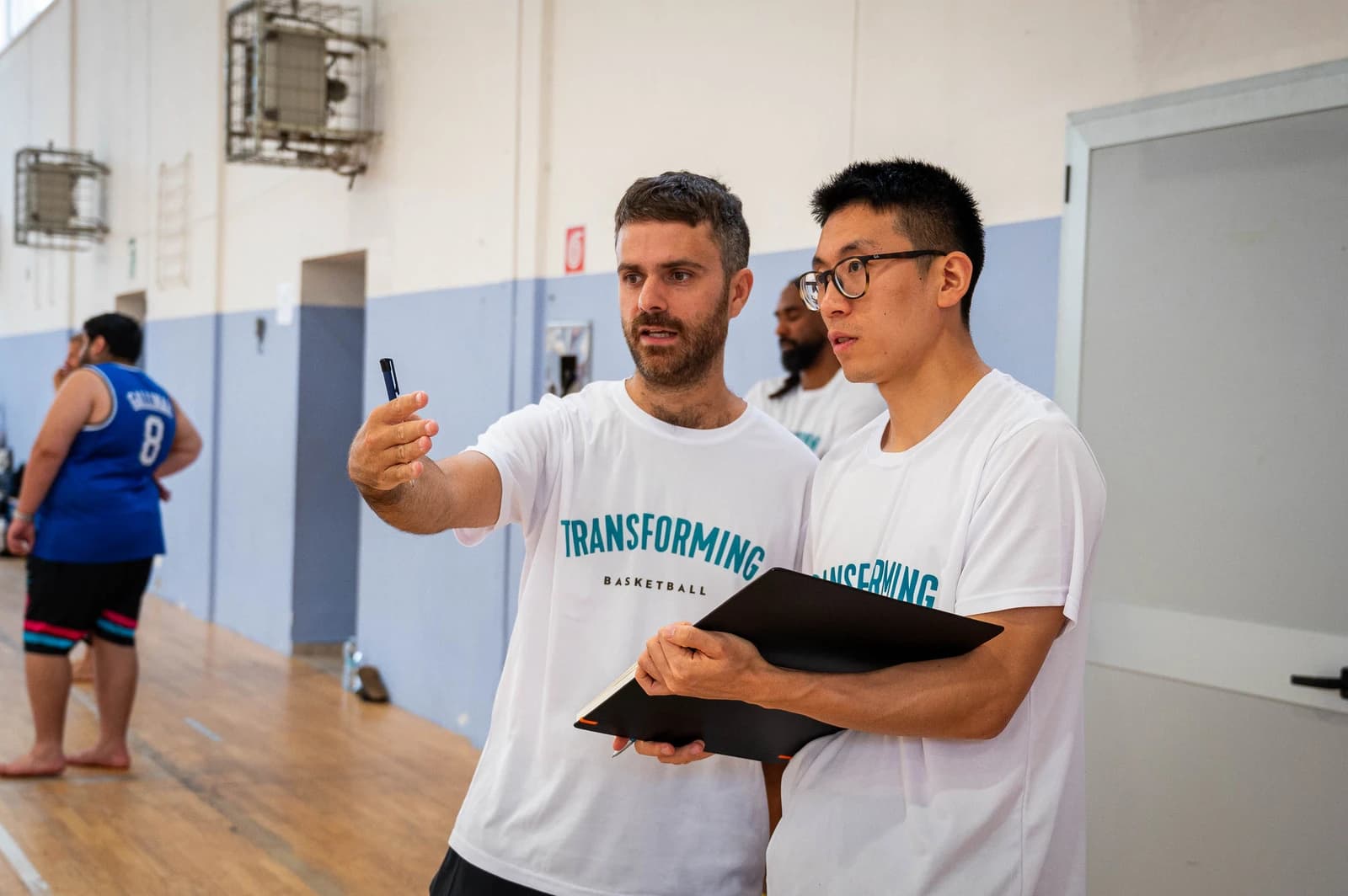 Coaches discussing an activity courtside at the Transforming Basketball summer camp in Roseto.